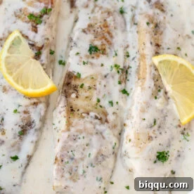 Fish in white sauce with lemon slices.