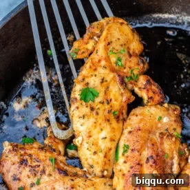 Spatula holding a cooked chicken tenderloin.