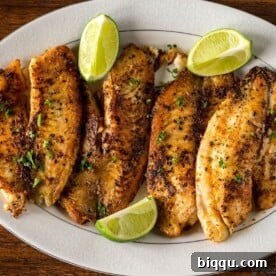 Pan Seared Tilapia on a serving tray with lime wedges