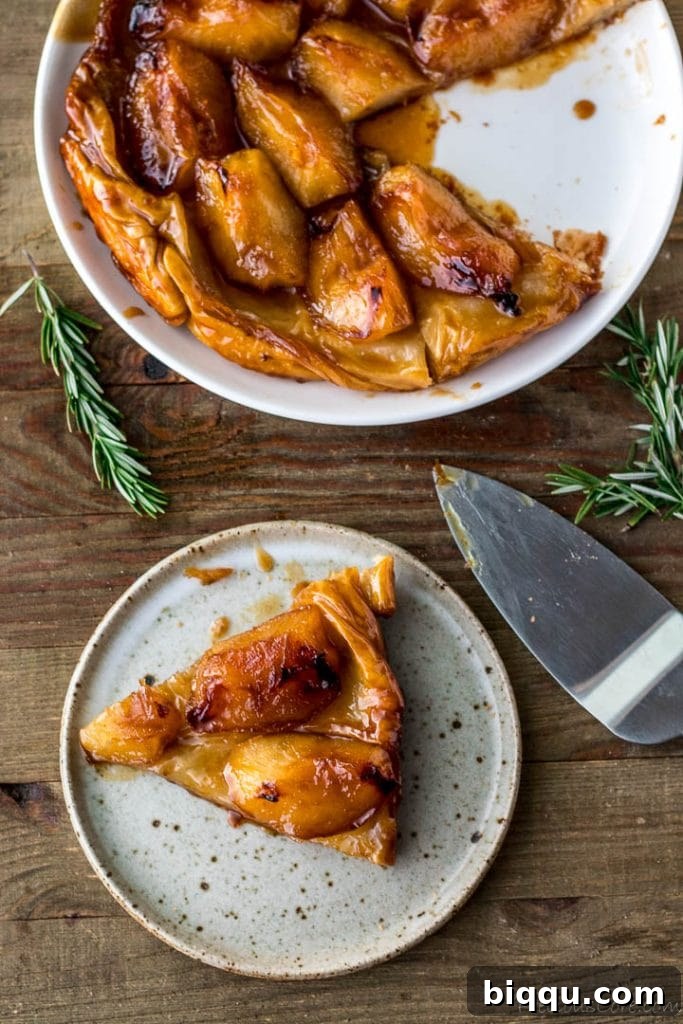Slice of Tarte Tatin on a plate, showcasing caramelized apples and flaky pastry