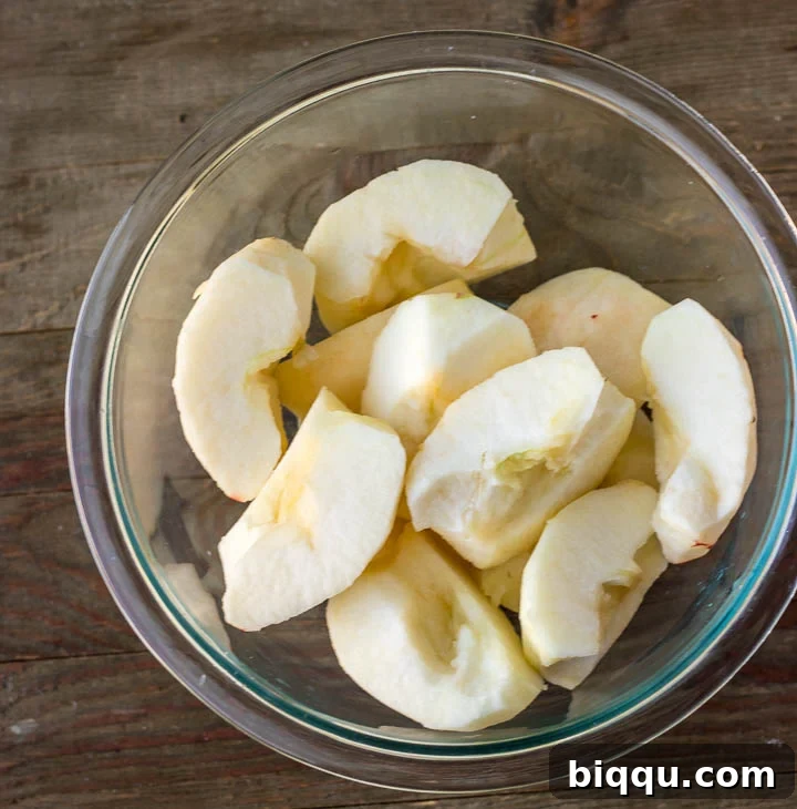 Bowl filled with perfectly peeled and cored apples, ready for caramelization
