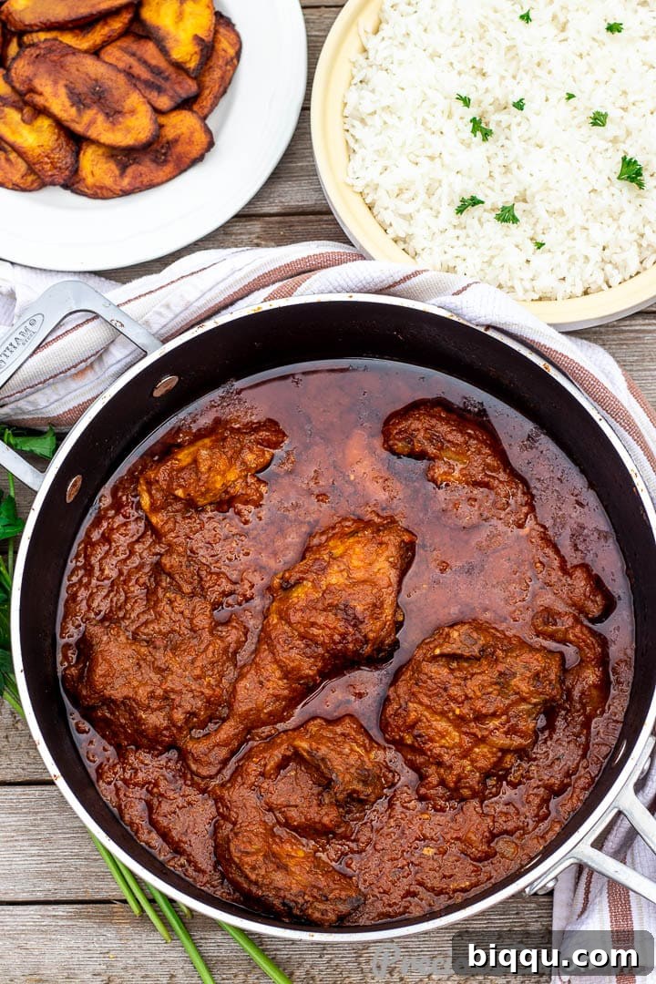 Bowls of African tomato stew, rice and plantains beautifully arranged.