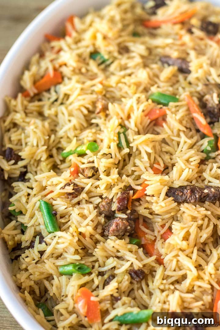 A close-up shot of fluffy Beef Fried Rice showing tender beef pieces, rice grains, and colorful vegetables.